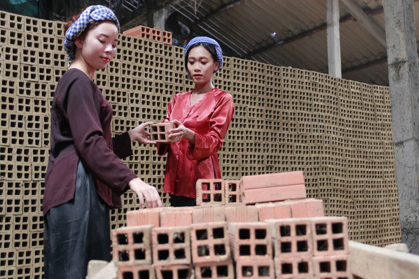 Autor robi sesję zdjęciową w piecu ceglanym Mang Thit w prowincji Vinh Long. Zdjęcie zrobione rankiem 23 sierpnia 2020 roku. Tradycyjna ceglana zawartość sceny. Ta cegła służy do budowy domów..  - Zdjęcie, obraz