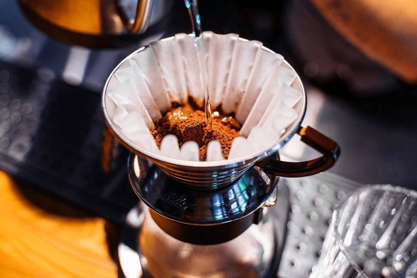 Közelkép a talajszemcsés pourover telepítéséről. Egy alternatív módszer a kávéfőzésre. Finom, fekete, gazdag kávé készült kiváló minőségű prémium Arabica. - Fotó, kép