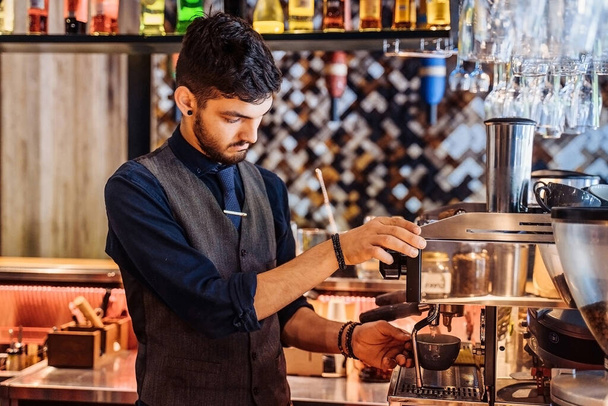Close-up van de barista die espresso maakt van een koffiezetapparaat in een restaurant, bar of pub. Professionele koffie zetten. Latte kunst met espresso machine stoom in het café. Vintage kleur toon. - Foto, afbeelding