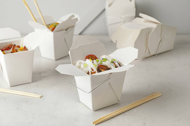 Schachteln mit leckeren Reisnudeln auf weißem Hintergrund - Foto, Bild
