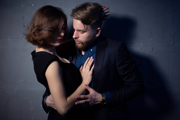 a young sexy couple passionately embraces in a room with low lighting - Photo, Image