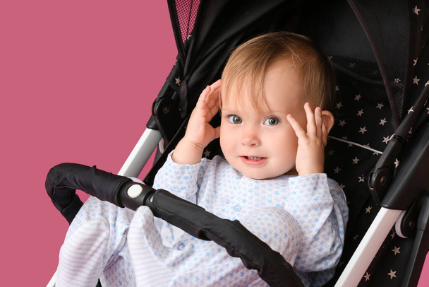 Schattig klein baby in kinderwagen op kleur achtergrond - Foto, afbeelding