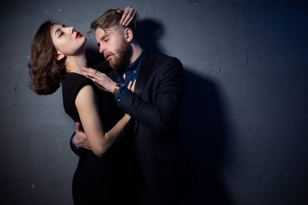 a young sexy couple passionately embraces in a room with low lighting - Photo, image