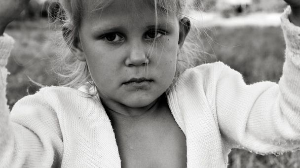 Nahaufnahme Schwarz-Weiß-Porträt von niedlichen grollenden und traurigen kaukasischen Kind. Die aufrichtigen Gefühle der Kinder. Kindheitsmomente. Kind in der Natur. - Foto, Bild