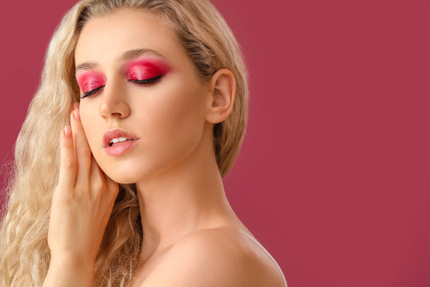 Young woman with beautiful eyeshadows on color background - Photo, Image