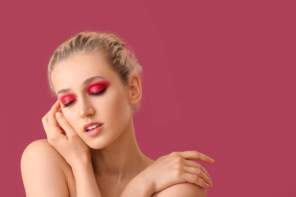 Young woman with beautiful eyeshadows on color background - Foto, afbeelding