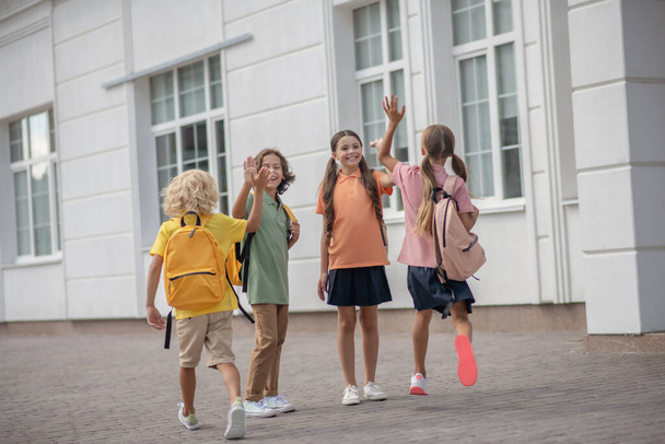 Schoolchildren meeting after lessons in school yard - Fotografie, Obrázek