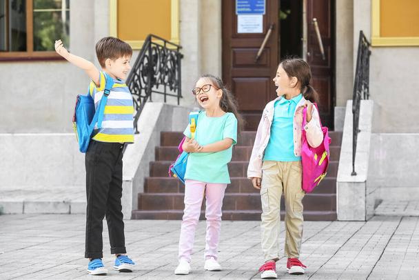 Щасливі маленькі учні біля школи на відкритому повітрі
 - Фото, зображення