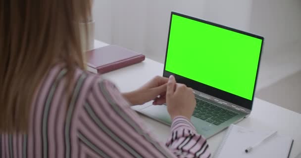 laptop zöld képernyővel chroma kulcs technológia munkaasztal tanulás vagy dolgozó nő, beszél video chat - Felvétel, videó