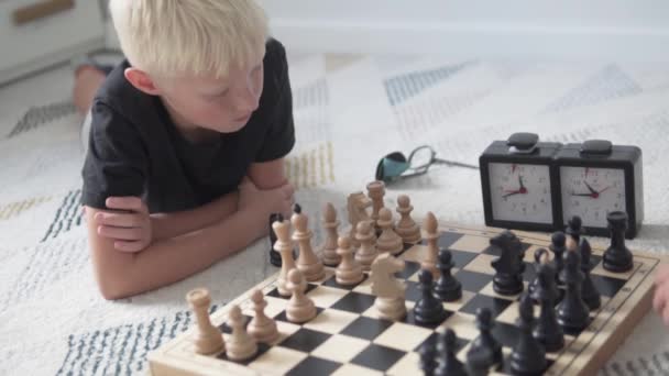 Chlapec blond hraje doma šachy - Záběry, video