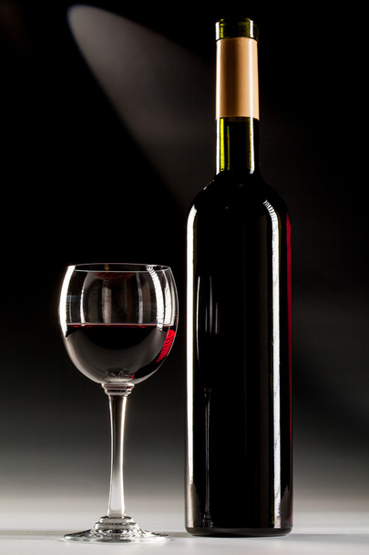 Filled glass of red wine and opened wine bottle - Foto, immagini