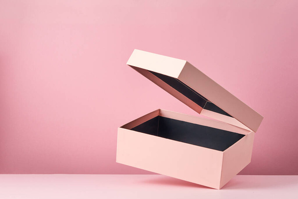 Pink open gift box isolated on pink background. Empty gift container. Mock up with flying box. - Foto, Imagem
