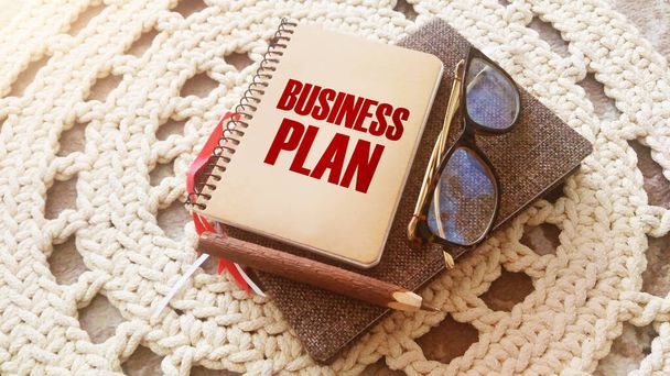Words Plan de negocios sobre portada de copybook, gafas, bolígrafo y libro Breve reseña de negocios y concepto de conclusiones. - Foto, Imagen