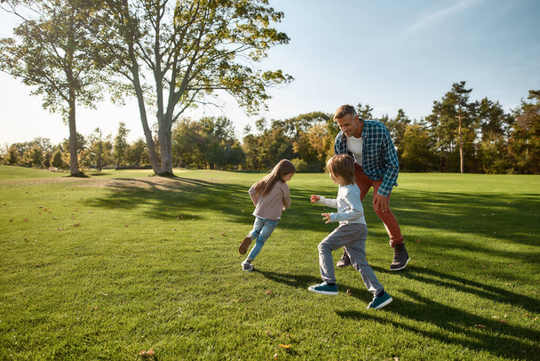 Supporting your childs emotional and physical growth. Excited family running outdoors on a sunny day - 写真・画像