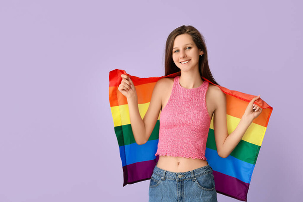 Young woman with LGBT flag on color background - 写真・画像