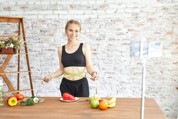 Woman healthy blogger is showing apple fruite and clean diet food. Vlogger recording vlog video live streaming at home.Fitness vlog concept. - Fotoğraf, Görsel