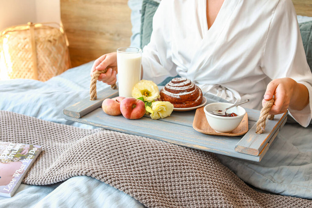 Young woman having tasty breakfast in bed - Foto, Bild