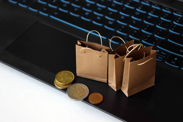 Malé řemeslné tašky pro nákup na pozadí klávesnice. Online nákupní koncept. Pohodlí pro nakupování bez opuštění domova. - Fotografie, Obrázek
