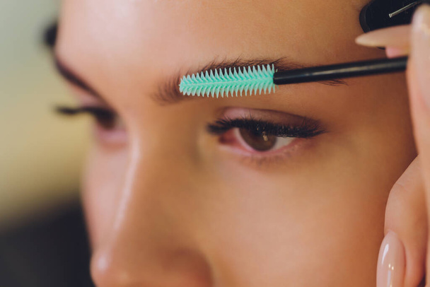 Young woman having professional eyebrow correction procedure in beauty salon. - Foto, Imagem