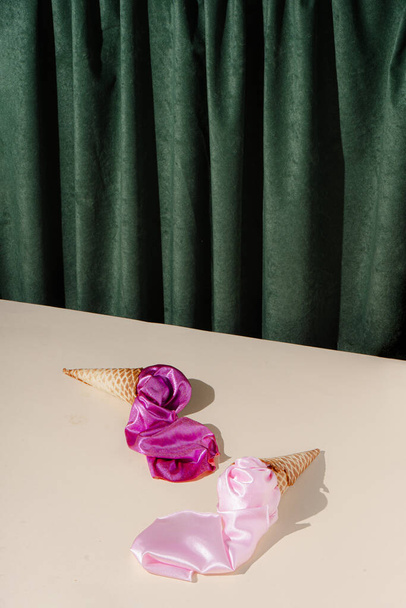 Concepto de estilo vintage con conos de helado y tela rosa. Fondo de cortina verde. Estética de moda retro. - Foto, Imagen