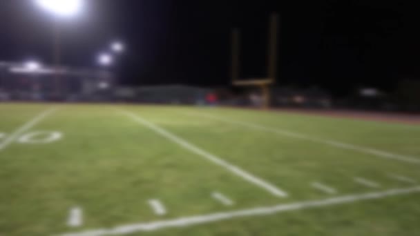 Defokussierte Pfanne über fast leeres Fußballfeld in der Nacht - Filmmaterial, Video