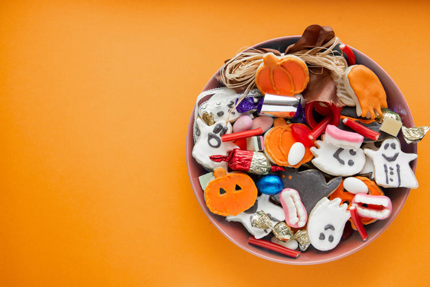 Halloween Jack o Lantern candy bowl with pumpkin sweets, candy and halloween cookies Trick or Treat - Foto, imagen