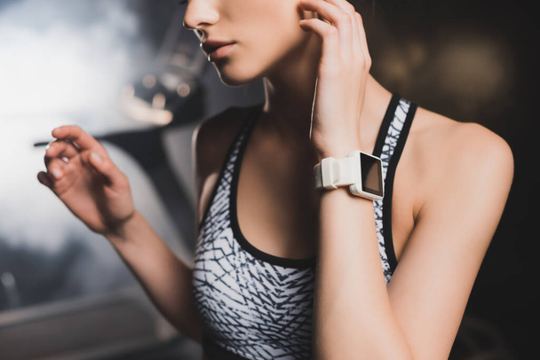 Cropped view of sportswoman with smartwatch in gym - Fotoğraf, Görsel