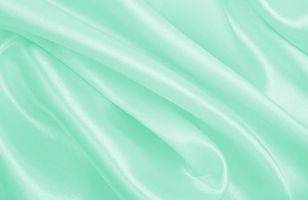 Smooth elegant green silk or satin luxury cloth texture can use as abstract background. Luxurious background design - Foto, Bild