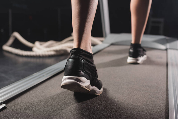 Cropped view of sportswoman running on treadmill in sports center  - Zdjęcie, obraz