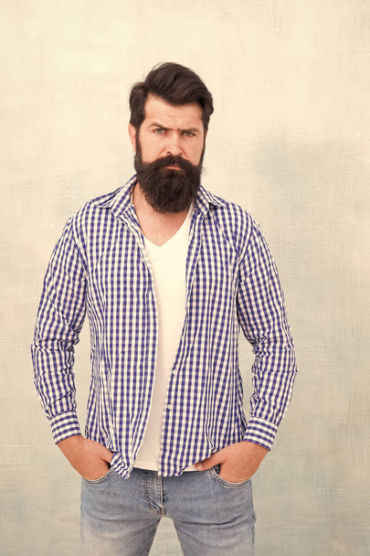 Self confidence. Well groomed guy. Brutal handsome hipster man grey wall background. Bearded man trendy hipster style. Masculinity and male beauty concept. Hipster with beard and mustache wear shirt - Zdjęcie, obraz