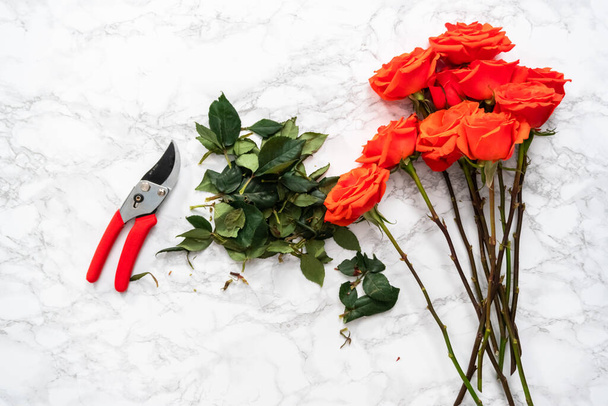 平置きだ。花配達花束を手配するための小さな耳で赤いバラを剪定. - 写真・画像
