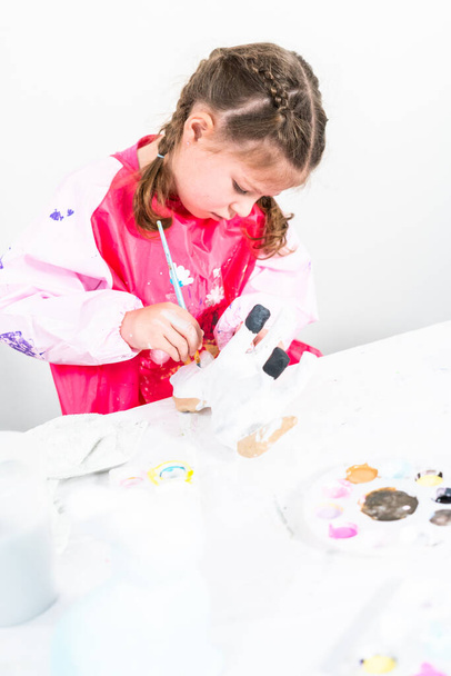 Маленькая девочка работает над своим художественным проектом дистанционного обучения дома во время пандемии COVID-19. - Фото, изображение