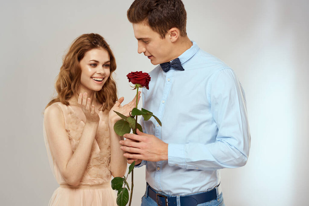 geliefden mannen en vrouw knuffels romantiek liefde rood roos licht achtergrond - Foto, afbeelding