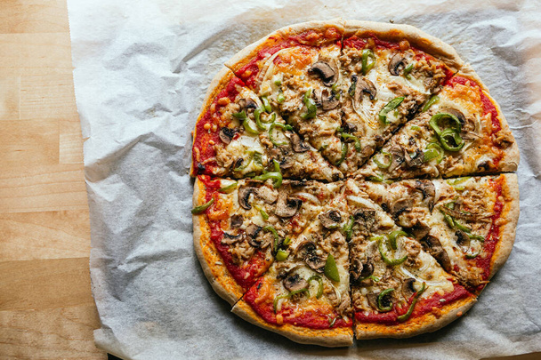 Pose plate d'une délicieuse pizza italienne maison au fromage, tomates, champignons et poivre vert - Photo, image