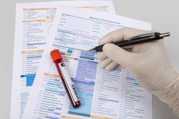 badanie krwi i formularz wniosku o przeprowadzenie analizy oraz ręka wypełniająca formularz - Zdjęcie, obraz