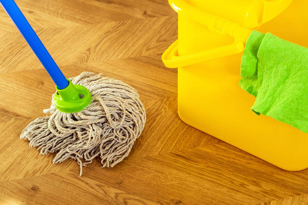 Pulizia del pavimento straccio e straccio su un secchio giallo. Il pulitore creerà igiene sulla casa. Servizio di pulizia - Foto, immagini