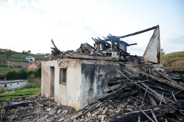 Yangından sonra bina harabeleri. Ev yanarak kül oldu. Köydeki eski harabe ve yıkılmış ev. Savaş sırasında evlerini yok ettiler.. - Fotoğraf, Görsel