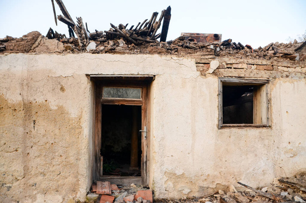 Ruiny budynku po pożarze. Dom spalony przez ogień. Stary zniszczony i zburzony dom we wsi. Zniszczony dom podczas wojny.. - Zdjęcie, obraz