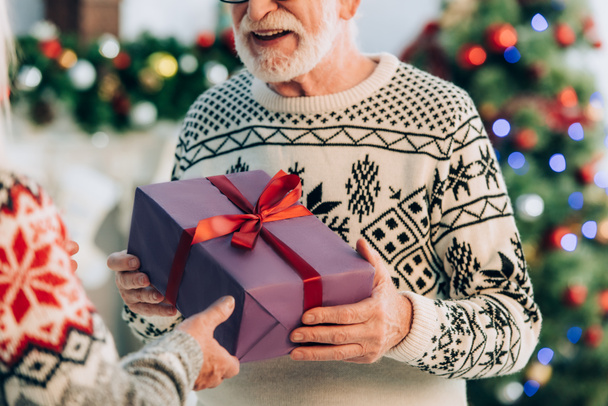 cropped view of senior man taking christmas gift from wife - Photo, Image