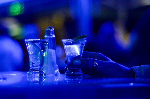 Un trago de tequila. Limones, sal y tragos en la mesa del club nocturno. Vaso de bebida alcohólica en el pub. - Foto, Imagen