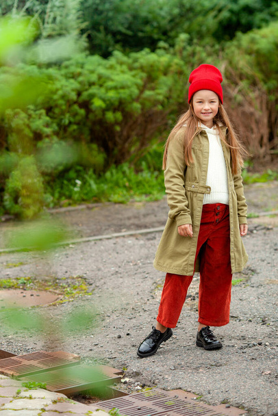 Girl in ordinary autumn clothes on a blurred plant background - Foto, Bild