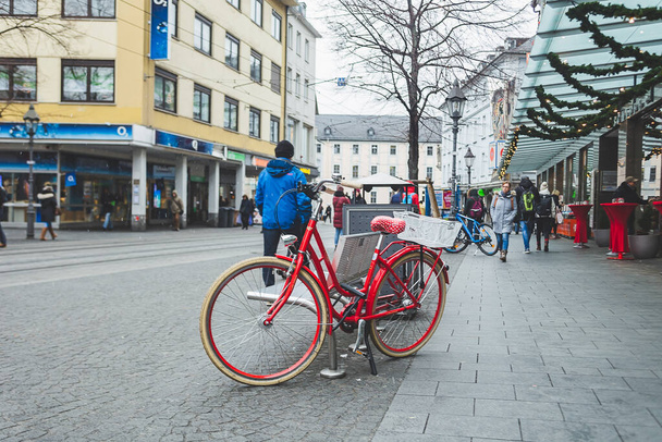 Wurzburg / Almanya-3 / 1 / 19: Kırmızı bisiklet Wurzburg şehir merkezindeki bir bankta kilitlendi - Fotoğraf, Görsel