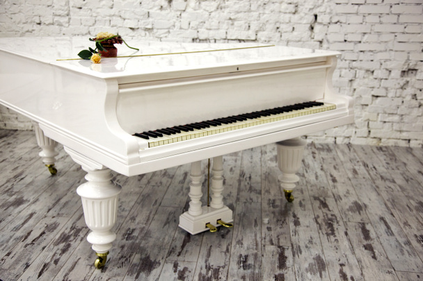 Біле піаніно з красивою жовтою трояндою
 - Фото, зображення