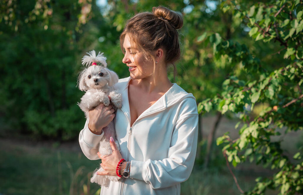 Frau mit einem kleinen modischen Luxus-Schoßhund beim Gassigehen, Haustier-Lebensstil - Foto, Bild