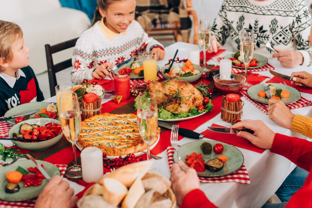 Selectieve focus van feestelijke tafel met Thanksgiving diner en familie thuis - Foto, afbeelding