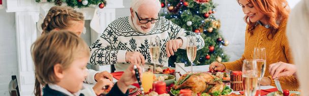 家族の話のパノラマショットと感謝祭の夕食を食べ、テーブルに座って - 写真・画像