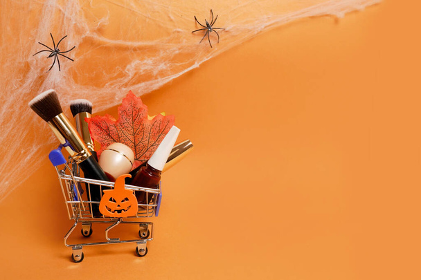Vrouwelijke cosmetica verkoop korting op Halloween achtergrond met spinnenweb, kopieer ruimte voor uw tekst. - Foto, afbeelding