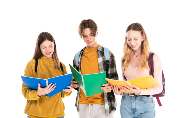 Teenagers smiling while looking at notebooks isolated on white - Foto, Bild
