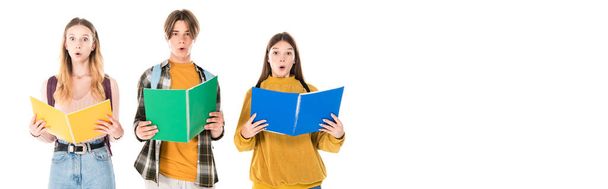 Panoramic shot of excited teenagers with backpacks holding notebooks isolated on white - Foto, imagen