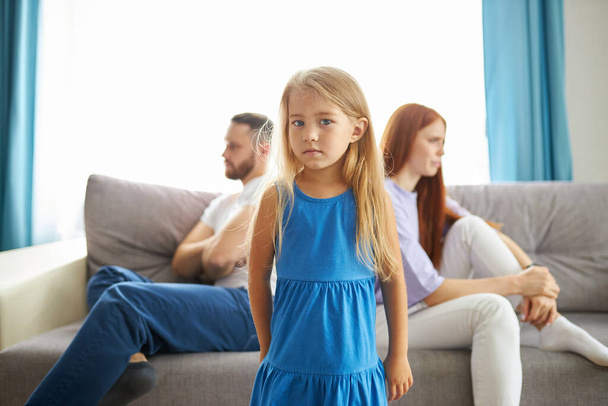 adorable child girl between depressed offended on each other parents - Foto, imagen